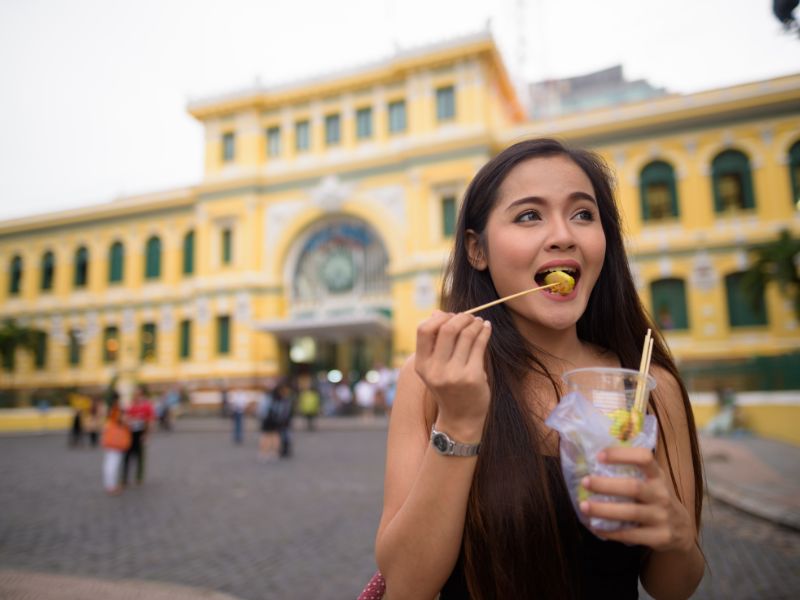 người phụ nữ ăn đồ ăn đường phố