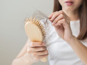 cô gái chải đầu thấy tóc rụng