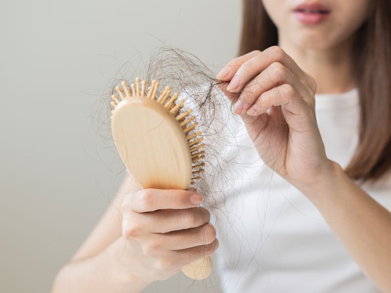 cô gái chải đầu thấy tóc rụng