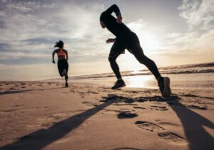 hai người đang chạy đuổi nhau trên bờ biển